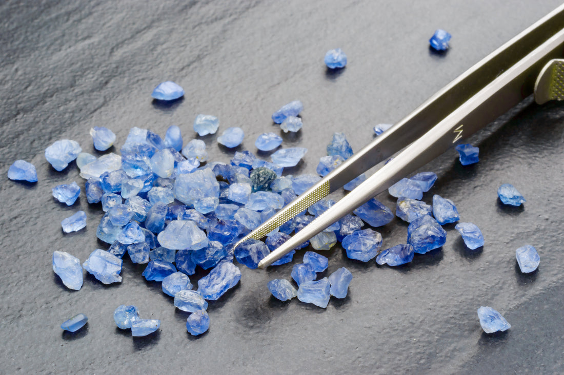 raw sapphires stones with tweezers