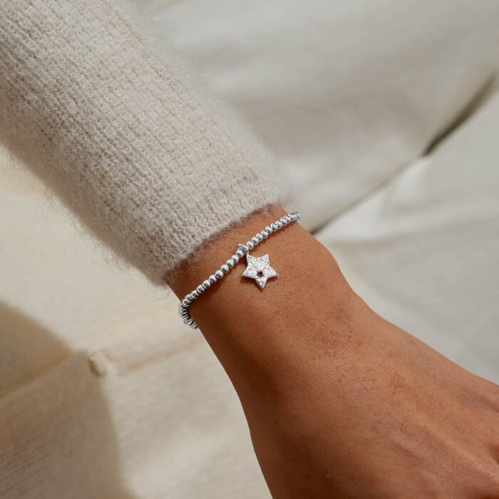 Silver star charm bracelet on a stretch cord.