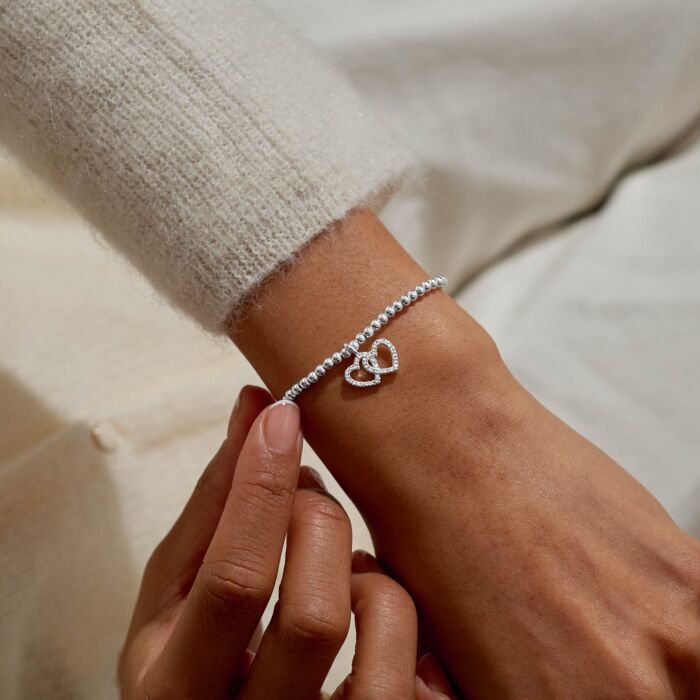Silver bracelet with two intertwined hearts.
