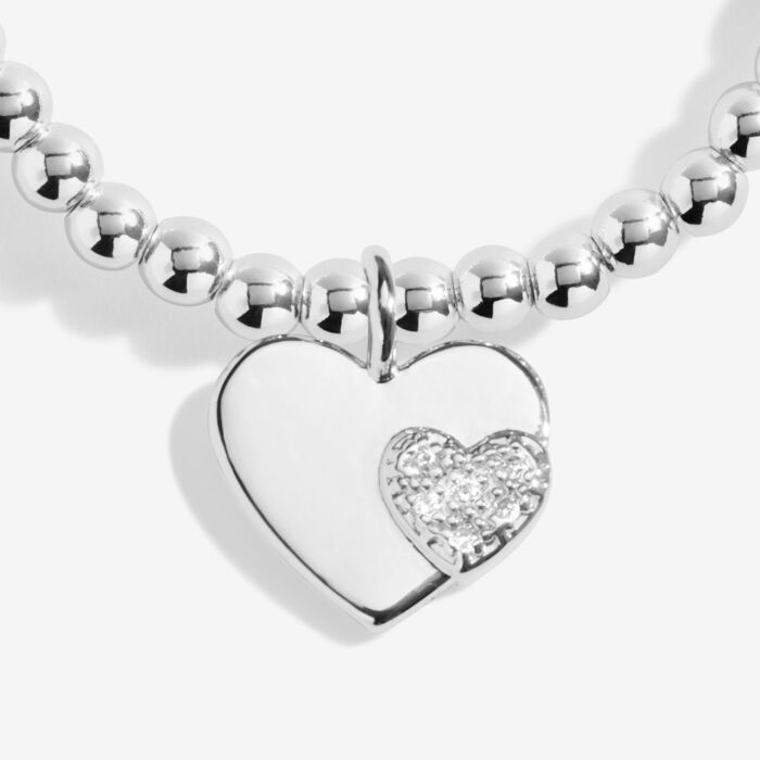 Silver heart charm bracelet on a stretchable beaded strand.