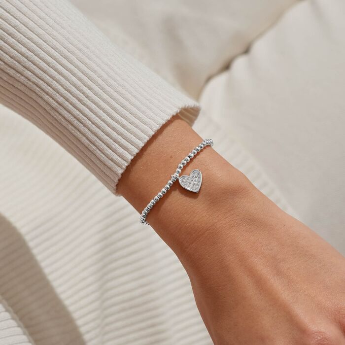 Silver heart charm bracelet with sparkling crystals.