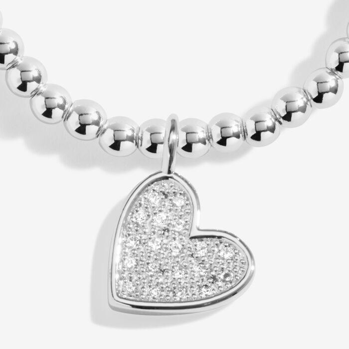 Silver heart charm bracelet with sparkling crystals.
