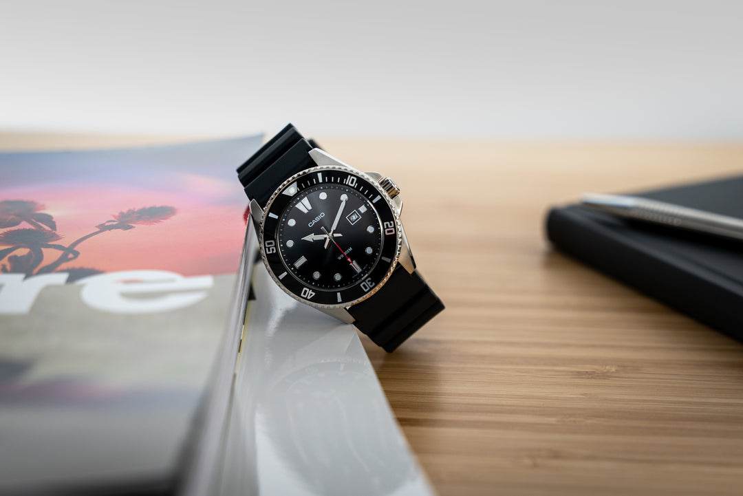 Men's black diver's watch with luminous hands and resin strap.