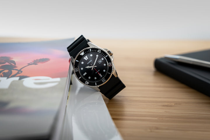 Men's black diver's watch with luminous hands and resin strap.