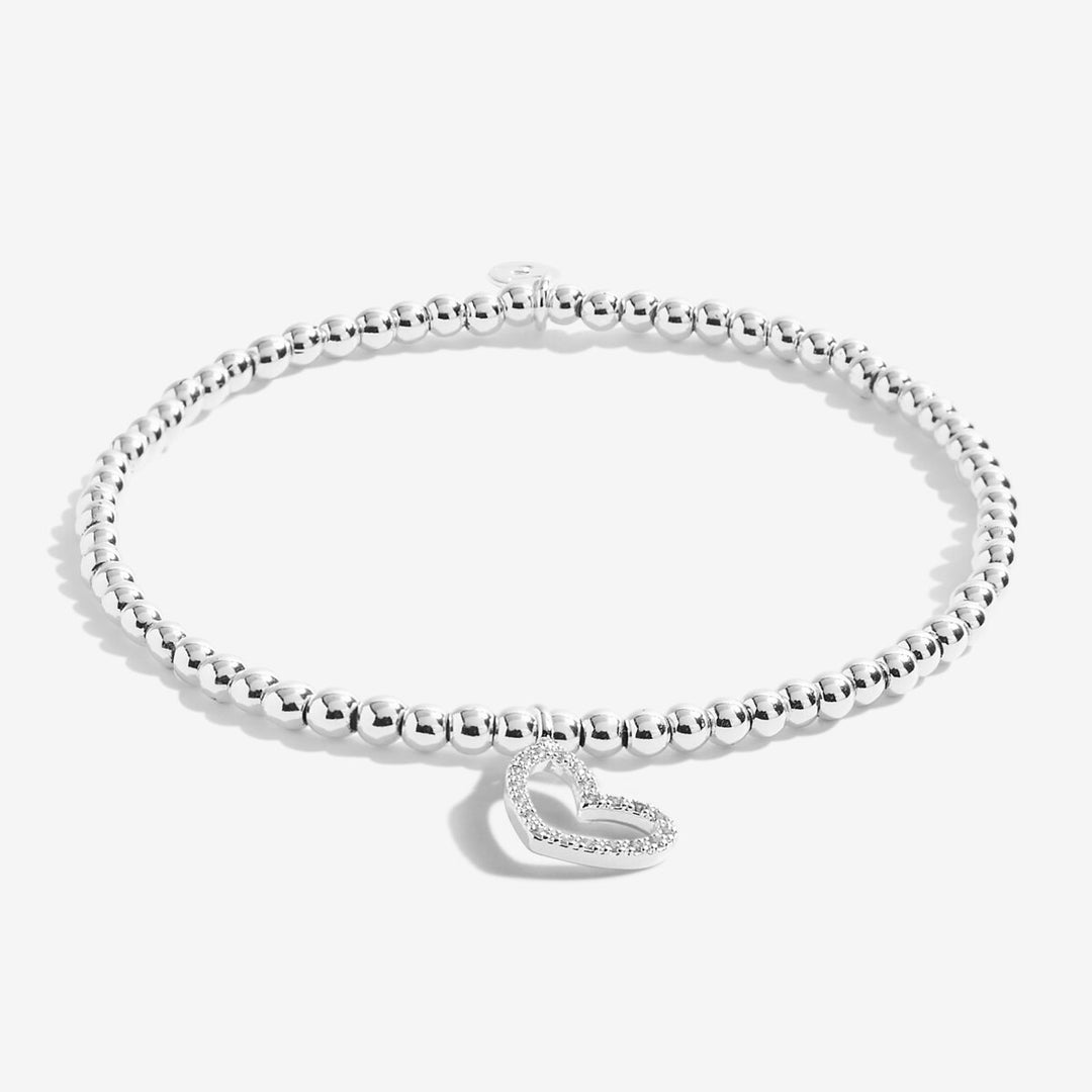 A silver beaded bracelet with a small heart-shaped charm set with clear stones, displayed on a clean white background.