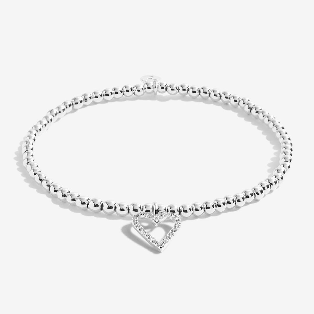 A silver beaded bracelet with a small open heart charm paved with clear stones, displayed on a clean white background.