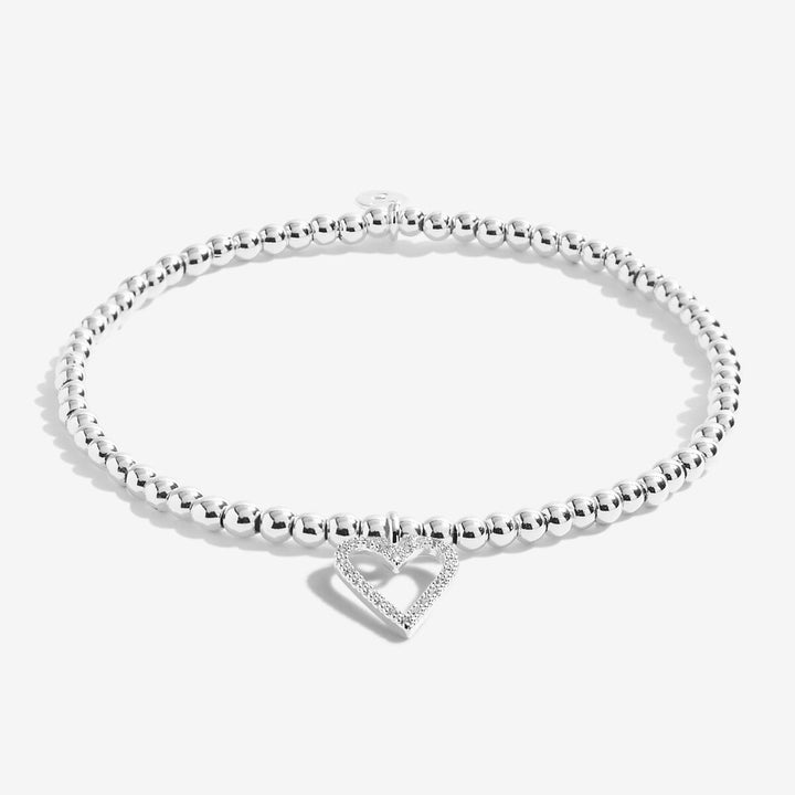 A silver beaded bracelet with a small open heart charm paved with clear stones, displayed on a clean white background.