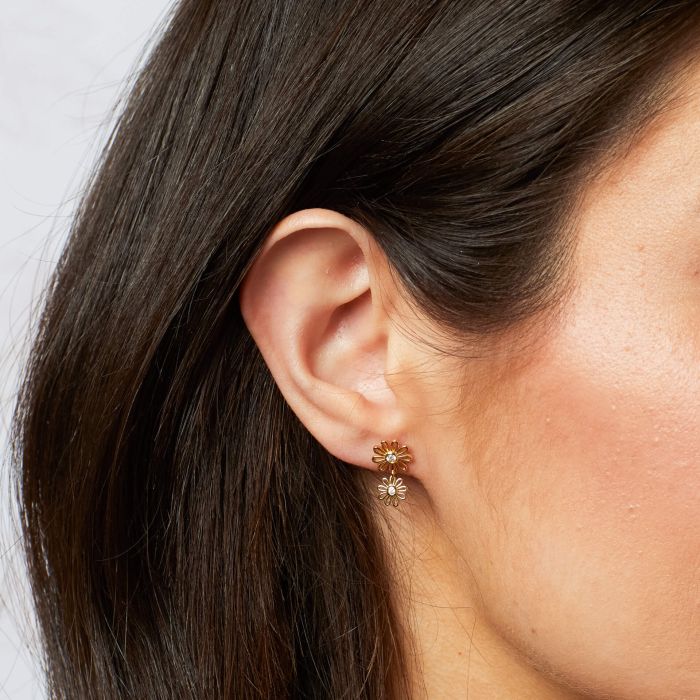 These are lightweight, yellow gold-plated, recycled sterling silver daisy drop earrings with a cubic zirconia center.