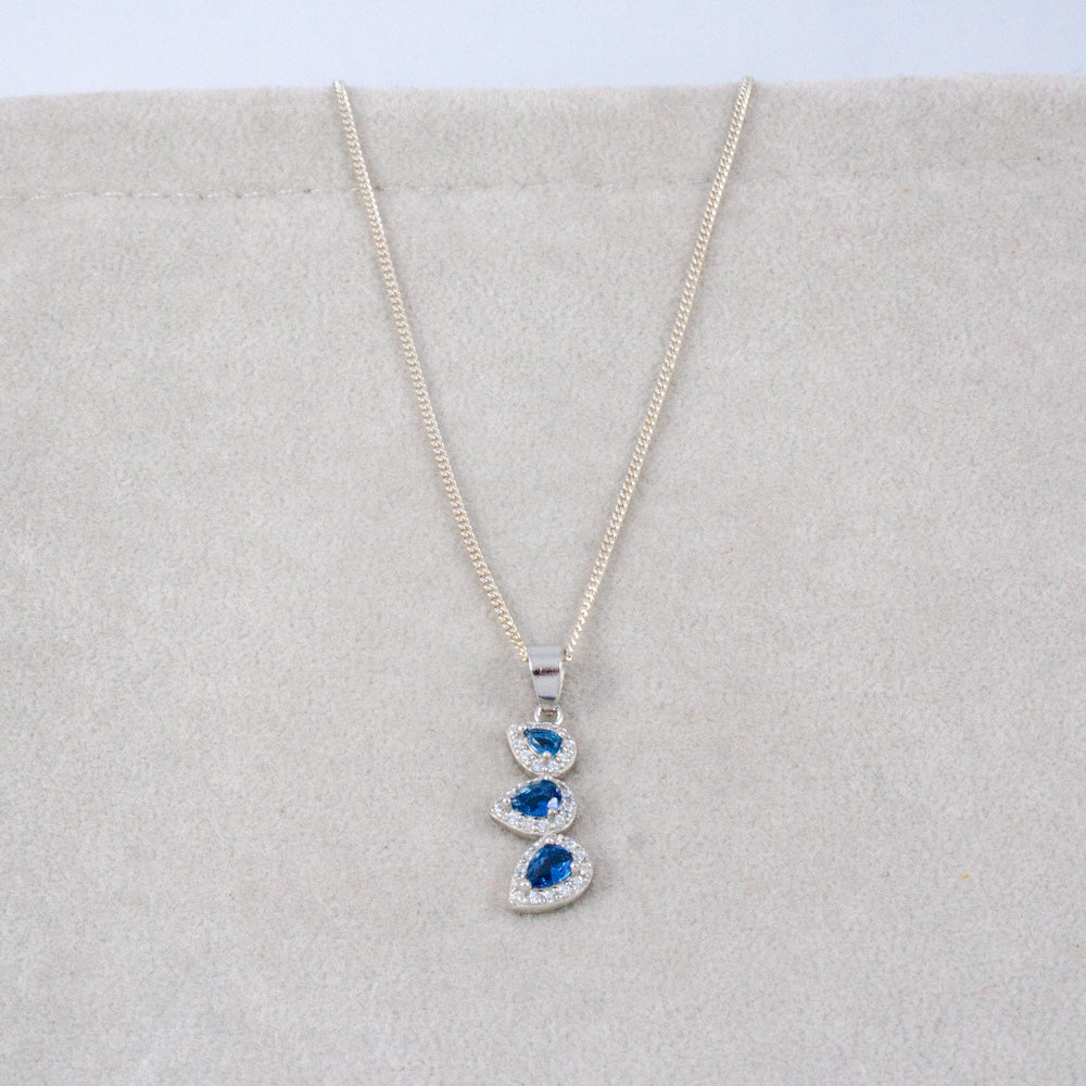 Necklace with a blue gemstone pendant on a light gray background