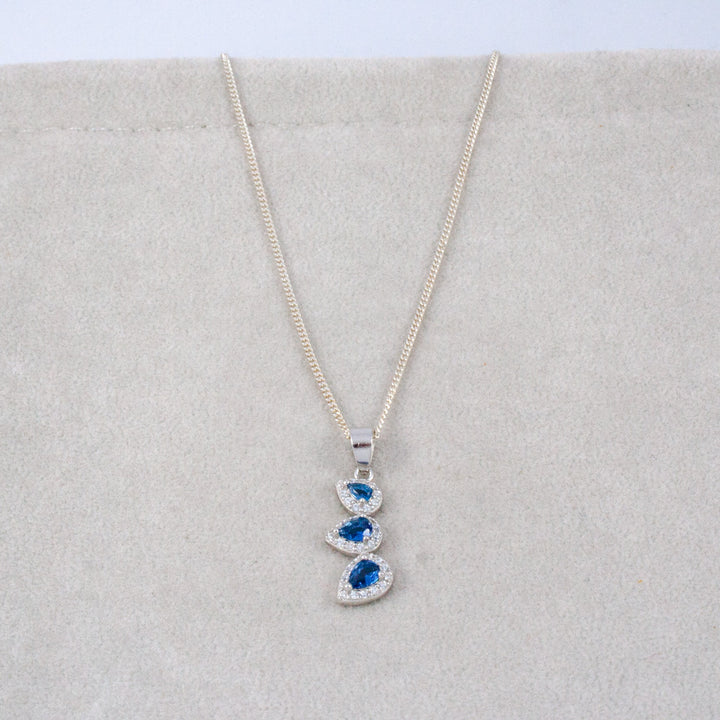 Necklace with a blue gemstone pendant on a light gray background