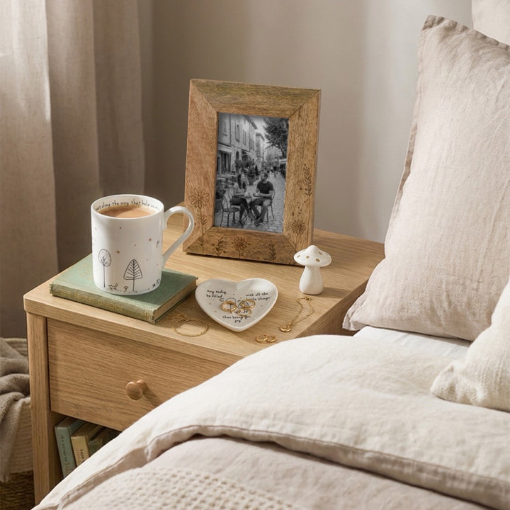Belly Button Wildflowers mango wood photo frame, shown in use with a photo on a bedside table.