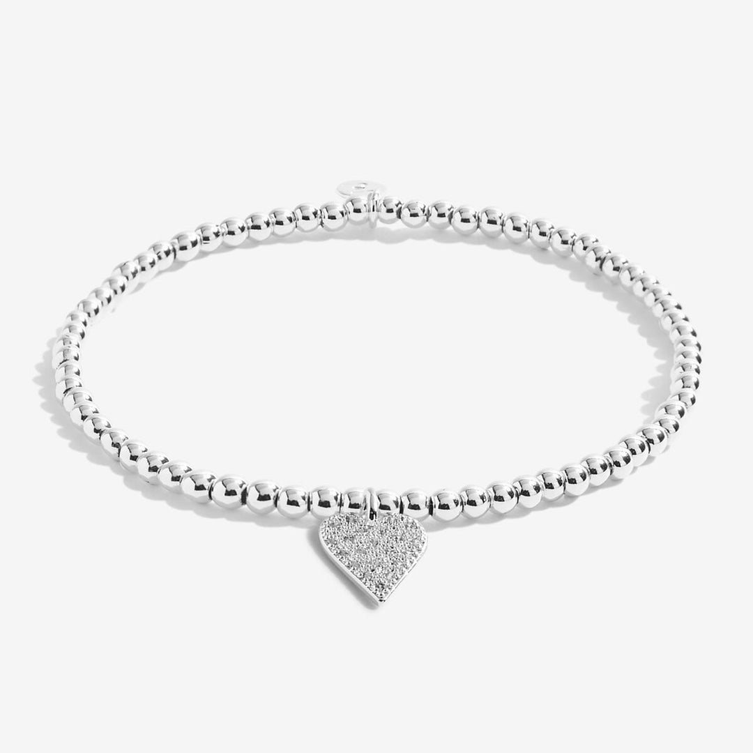 a silver-plated beaded bracelet with heart charm on white card 