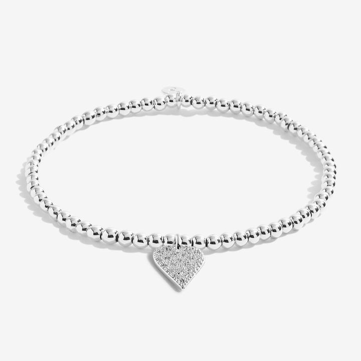 a silver-plated beaded bracelet with heart charm on white card 