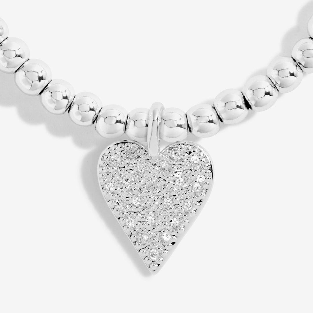 a silver-plated beaded bracelet with heart charm on white card 