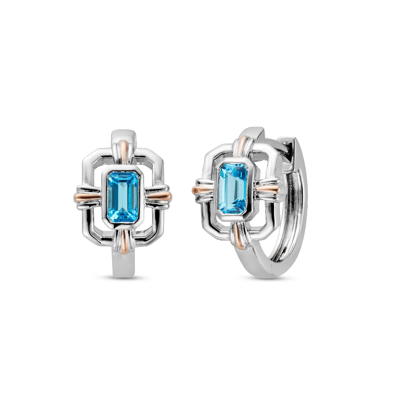 Pair of silver hoop earrings with blue gemstones on a white background