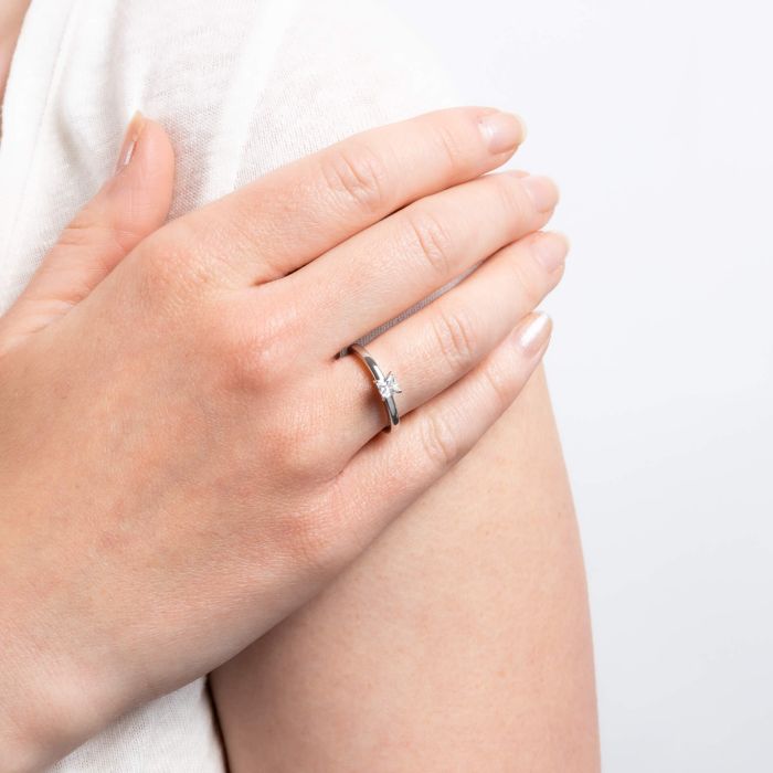 Princess cut solitaire ring with a silver band.