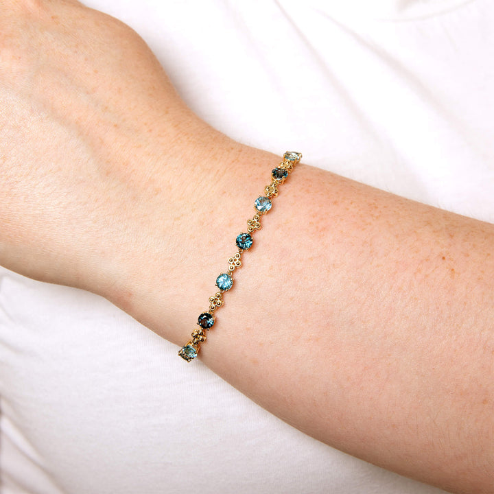 The 9ct gold blue topaz bracelet worn on the wrist.