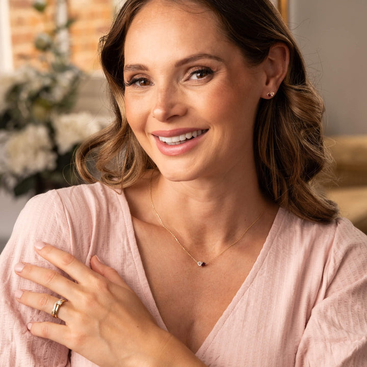 Woman wearing a pink top with a blurred indoor background