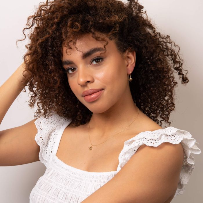 Gold starburst hoop earrings.