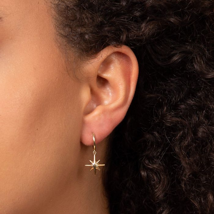 Gold starburst hoop earrings.