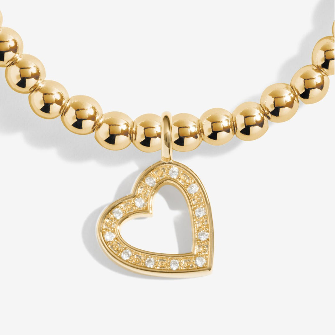 Gold beaded bracelet with an open heart charm.