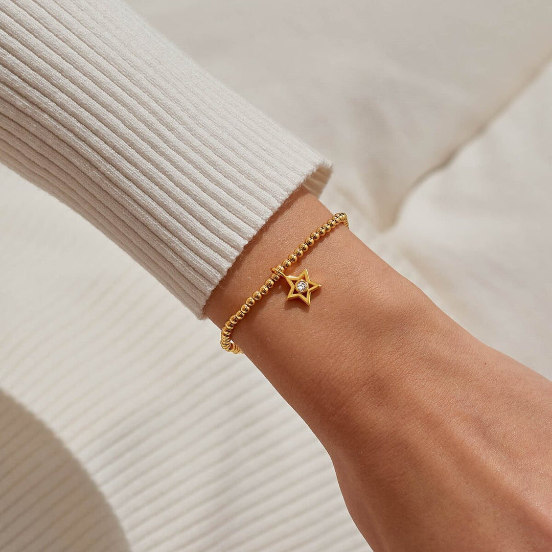 Gold beaded bracelet with a star charm.