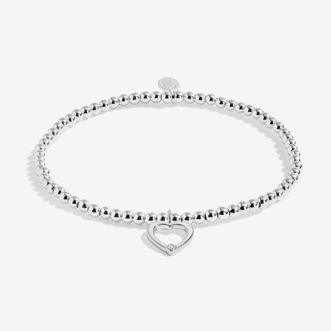 Silver bracelet with an open heart charm.
