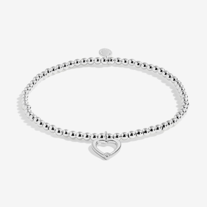 Silver bracelet with an open heart charm.