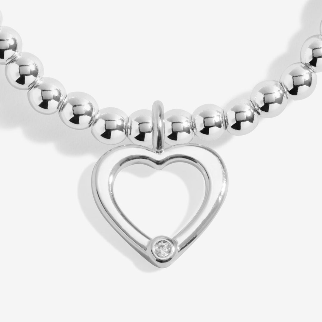Silver bracelet with an open heart charm.