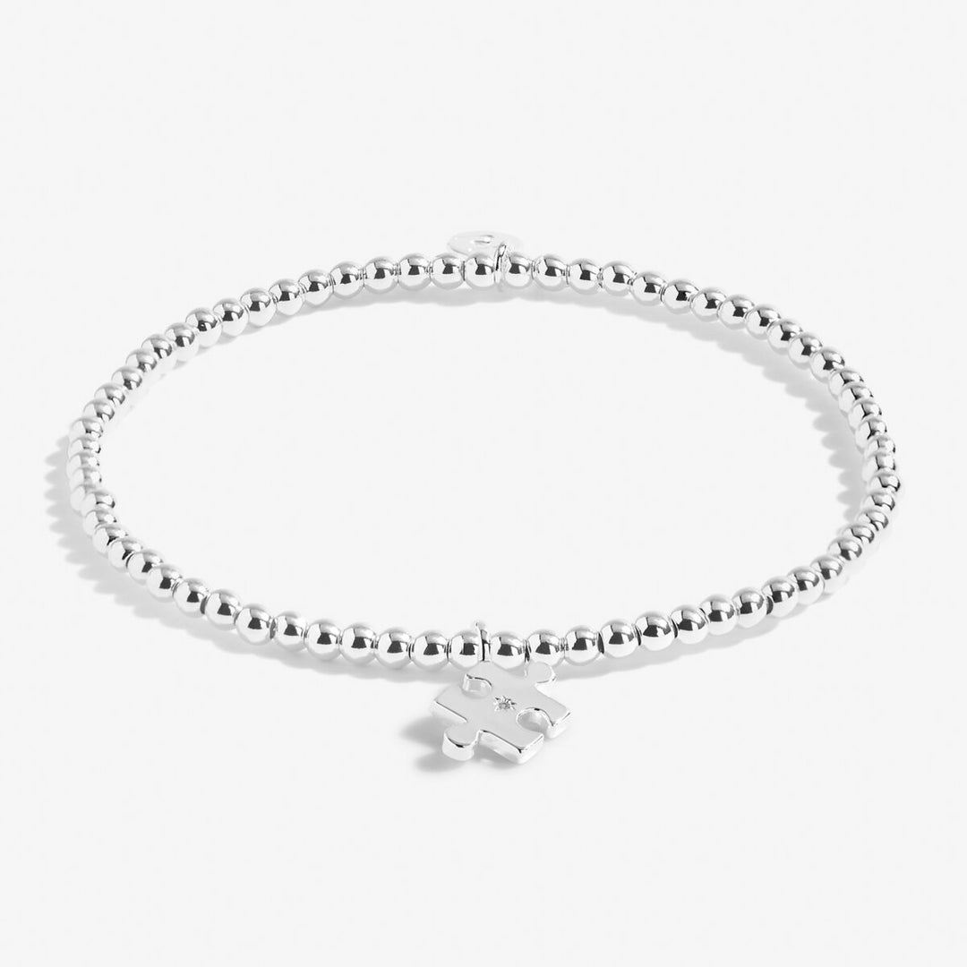 Silver bracelet with a heart-shaped tag on a white background