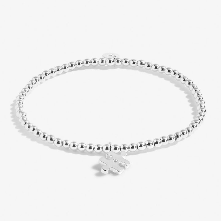 Silver bracelet with a heart-shaped tag on a white background