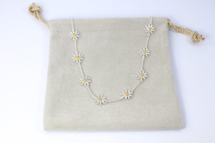 Two-tone daisy necklace with gold and silver flowers.