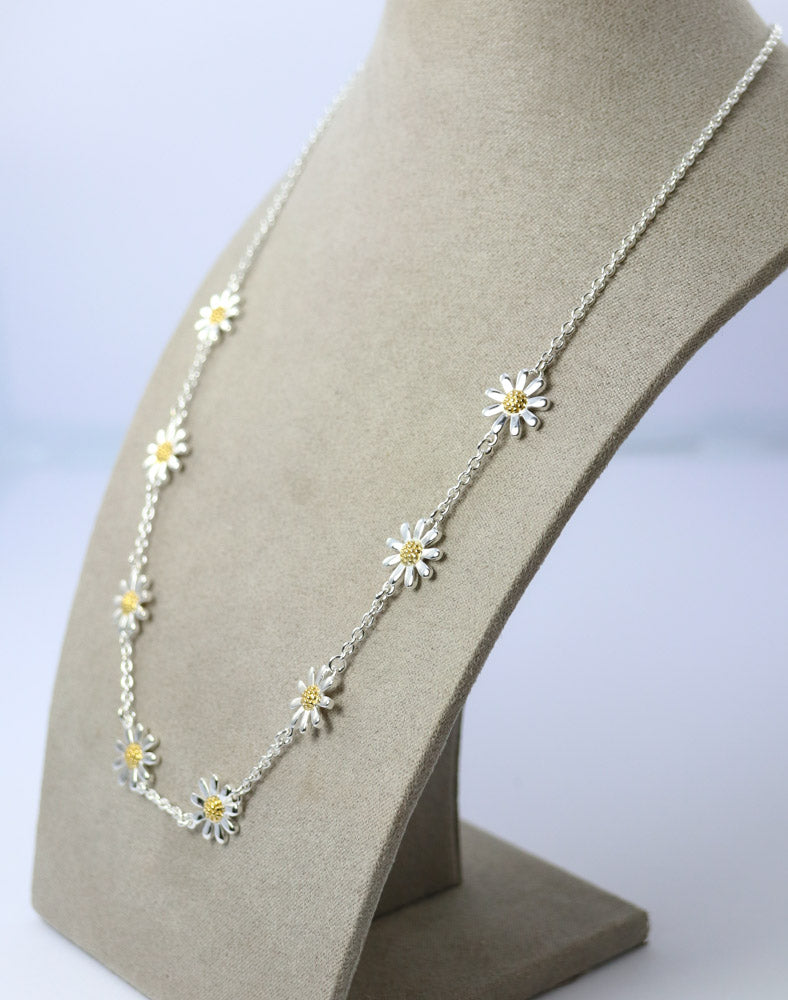 Two-tone daisy necklace with gold and silver flowers.