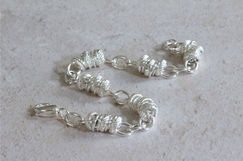 silver bracelet with oval and circular serated links | Carathea