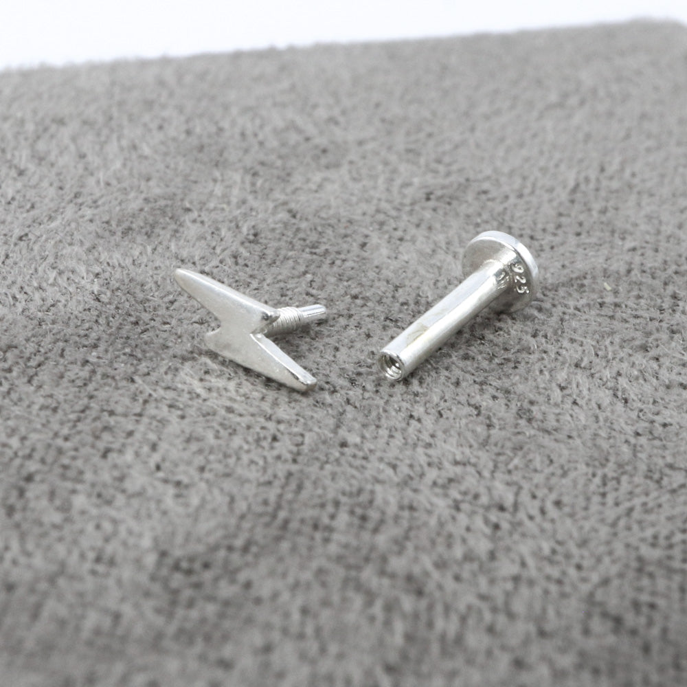 Sterling silver lightning bolt labret stud with its top unscrewed beside the flat-backed post.