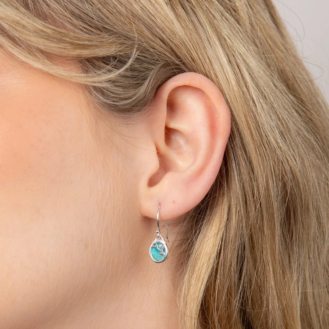 These are turquoise drop earrings with sterling silver settings and flower patterns, suitable as a December birthstone gift | Carathea & Jools