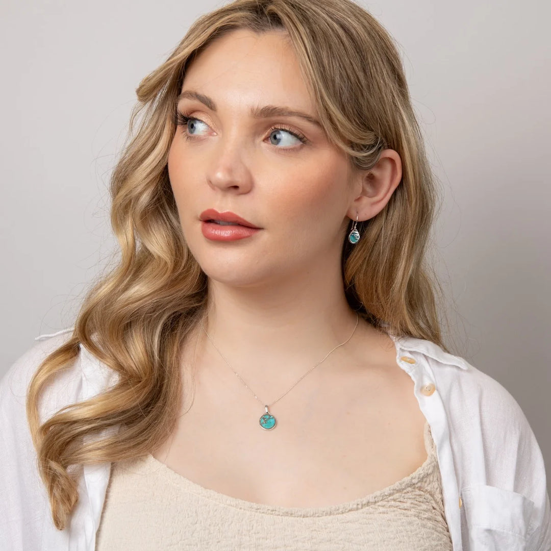 These are turquoise drop earrings with sterling silver settings and flower patterns, suitable as a December birthstone gift | Carathea & Jools