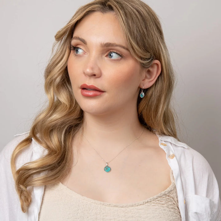 These are turquoise drop earrings with sterling silver settings and flower patterns, suitable as a December birthstone gift | Carathea & Jools