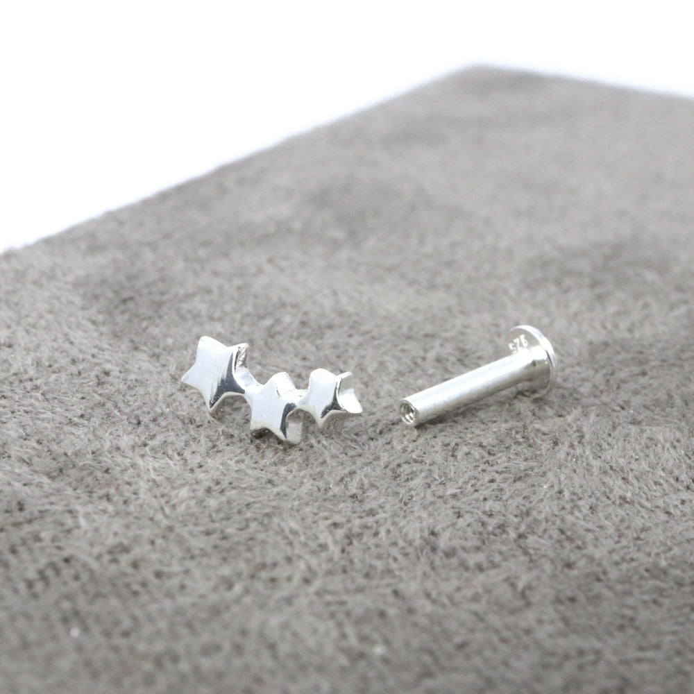 Sterling silver three star climber labret stud with its top unscrewed beside the flat-backed post.