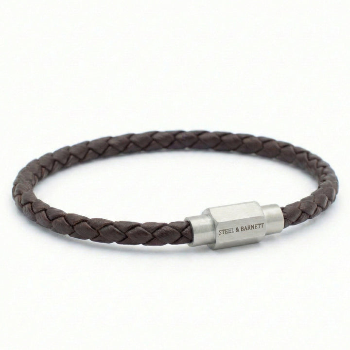 Brown braided leather bracelet with a silver clasp on a white background