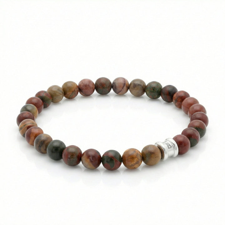 Beaded bracelet with cherry creek jasper beads and a silver charm on a white background