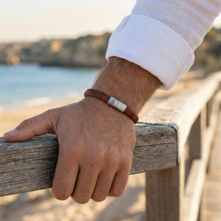 Hand wearing a Steel and Barnett bracelet with a scenic background